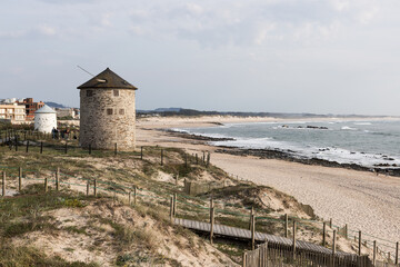 Fototapeta na wymiar Windmills and coastal path at beach Praia da Apúlia, Esposende, Portugal