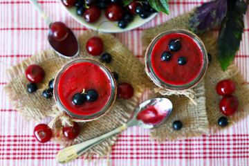 Selective focus. Detox smoothie with cherries and black currants. Smoothie with berries and basil. Vegan diet. Fresh homemade smoothie. Healthy summer dessert.