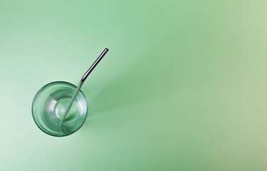 Drinking metal straws for summer cocktails. Zero waste organic ecology tubes on green background with copy space