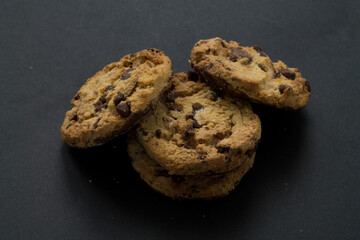 Group of chocolate chip cookies on black background.