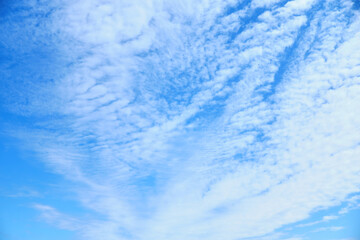Blue summer sky with stretched and blurred white clouds