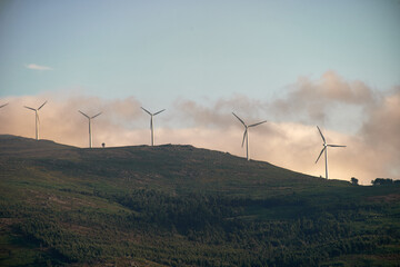 green mountain landscape with electric windmills and fog