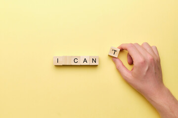 Motivational phrase concept - I can. Hand holds a wooden block.