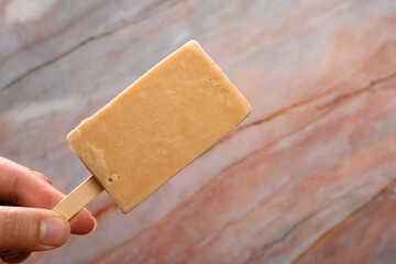Fototapeta premium hand holding a fresh tapioca milk tea flavor popsicle