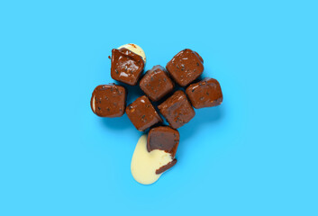 top view chocolate blocks with vanilla flavor ice cream inside starts melting on blue background