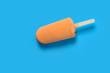 top view fresh orange color chocolate outer popsicle with beans inside on blue background