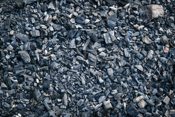 Black charcoal texture background. Close-up shot. Top view.