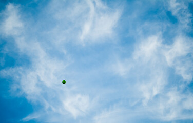 Fototapeta na wymiar Green balloon floating away