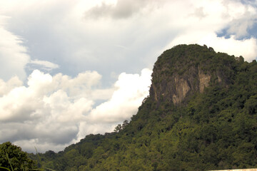 Stormy cloud formation with a rocky mountain outcrop in the foreground