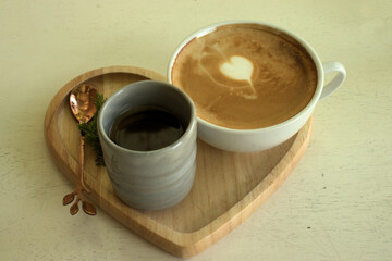 Coffee and tea with a brass spoon on a wooden serving plate