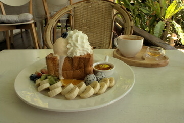 Very appetizing platter of bananas, kiwi fruits and berries with toast, ice cream and whipped cream 
