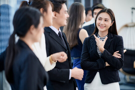 A group of business employee and managers are discussing during a seminar or meeting break.