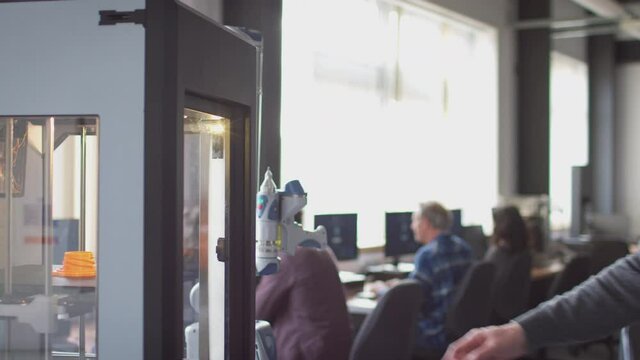 Mature male college student studying engineering using 3D printing machine - shot in slow motion