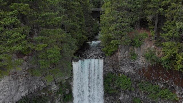 Aerial footage of a large waterfall in a mountain forest. 4k 24fps.