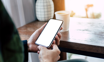 cell phone mockup image blank white screen.woman hand holding texting using mobile on desk at coffee shop.background empty space for advertise.work people contact marketing business,technology