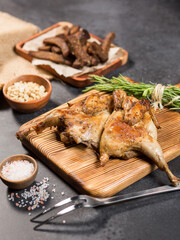 grilled chicken on a wooden board, on a gray background, with sauce, black bread