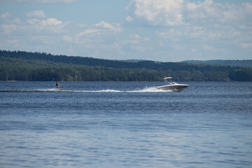Obraz premium Person water skiing behind big boat on Round Lake, Ontario, Canada 