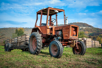 Low angle view of an old rusted Soviet tractor with a trailer