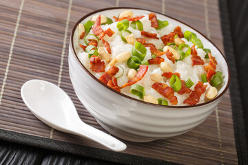 Jook congee is a type of rice porridge that's popular in many parts of Asia close-up in a bowl on the table. Horizontal
