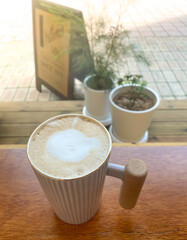 Cappuccino in a white mug on a cafe table, vintage feel
