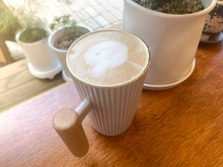 Cappuccino in a white mug on a cafe table, vintage feel
