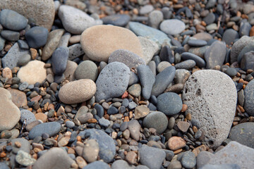Fototapeta na wymiar rocky beach from assorted gray stones textured background