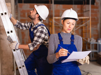 Female foreman checking the work of the builders in house. High quality photo