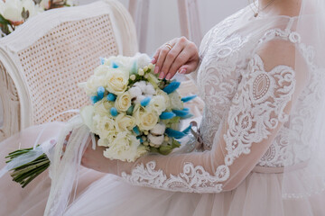bride sitting in studio with wedding bouquet
