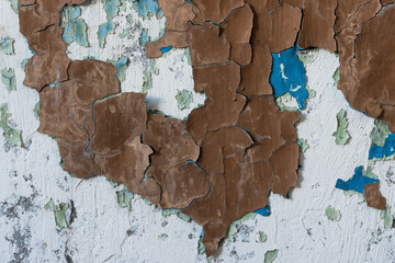 Peeling paint on the wall. Old concrete wall with cracked flaking paint. Weathered rough painted surface with patterns of cracks and peeling. High resolution texture for background and design. Closeup