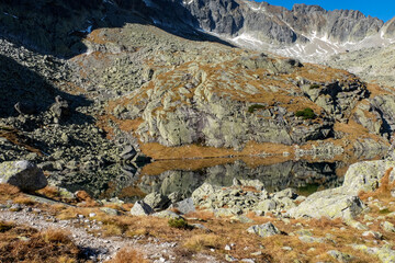 Lake in mountains. Pond in Valley of Five Spis Lakes surrounded by rocky summits, High Tatra Mountains, Slovakia.