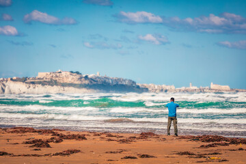 Tourist takes a picture of Vieste town. Great spring seascape of Adriatic sea, Gargano National Park, Apulia region, Italy, Europe. Traveling concept background.