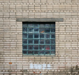 A window made of glass blocks in a white brick wall