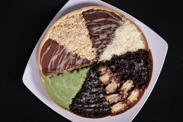 Terang Bulan or sweet martabak is a street food in Indonesia with the basic ingredients of flour and sugar. full color snacks isolated black background