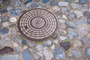 Sewer hatch on cobblestone pavement