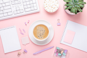 Office workplace desk table with computer, succulent, supplies and coffee in pastel colors. Top view