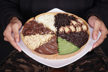 Terang Bulan or sweet martabak is a street food in Indonesia with the basic ingredients of flour and sugar. full color snacks isolated black background
