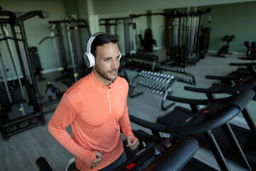 Fototapeta na wymiar Young athlete warming up on a treadmill during sports training in a gym