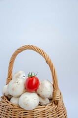 Basket with mushrooms and tomato on top. Mushrooms tomato contrast. Shopping cart.