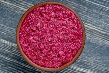Obraz na płótnie Canvas Red horseradish sauce with beetroot isolated on wooden background, closeup, top view. Concept of healthy eating