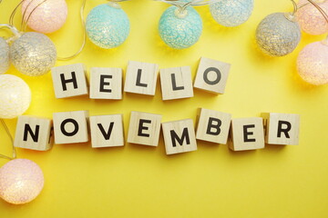 Hello November alphabet letter with LED Cotton ball Decoration on yellow background