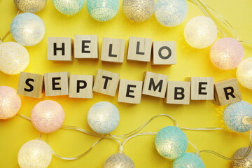 Hello September alphabet letter with LED Cotton ball Decoration on yellow background