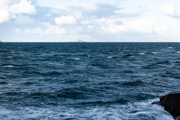 Fototapeta na wymiar The grey blue cool Atlantic ocean in Bretagne France with a cloudy friendly sky and no boat.