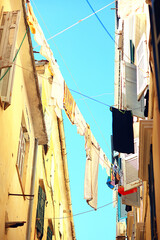 Fototapeta na wymiar linen is dried in a narrow street of Italy, Italian lifestyle