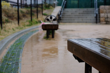 雨が降る公園のベンチ