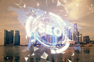 SEO hologram on city view with skyscrapers background double exposure. Search optimization concept.