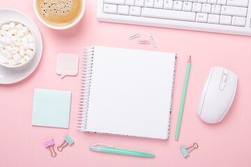 Office workplace desk table with computer, supplies, coffee and marshmallow in pastel colors. Top view