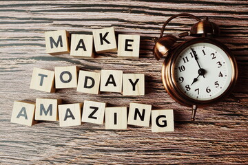 Make Today Amazing alphabet letter with alarm clock on wooden background