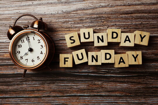 Sunday Funday alphabet letter with alarm clock on wooden background