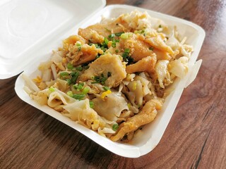 Stir fried rice noodles with chicken on a foam box container.  Thai style noodles.  Concept of online delivery food and takeaway.  Selective focus.  