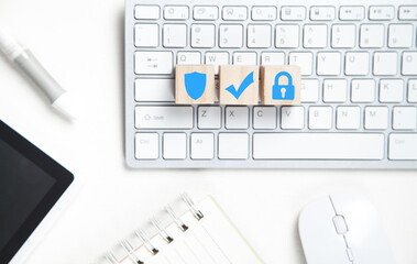 Shield, check mark, padlock on wooden cubes. Keyboard and other business objects. Internet and technology security